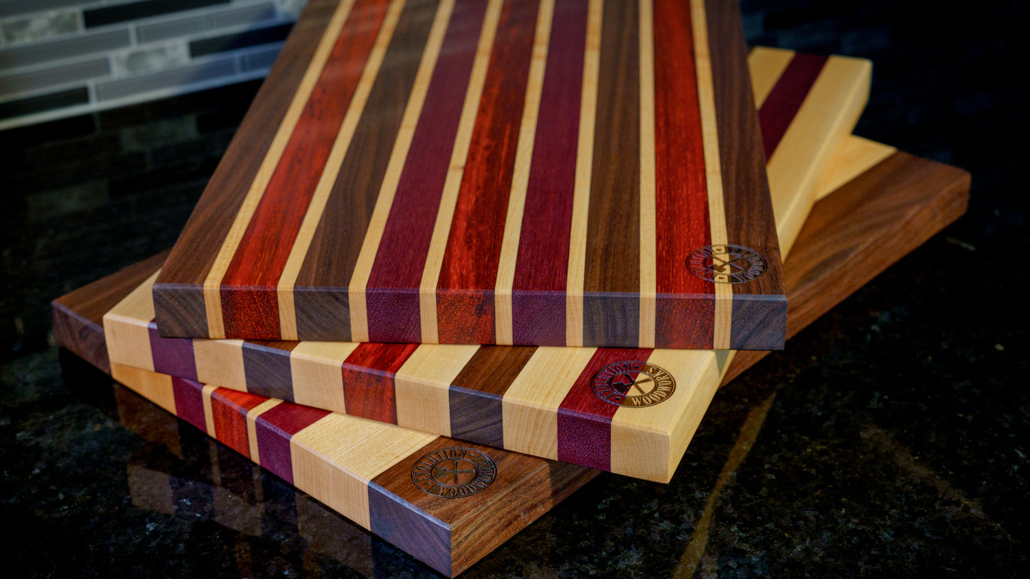 Stack of edge grain cutting boards of different colors